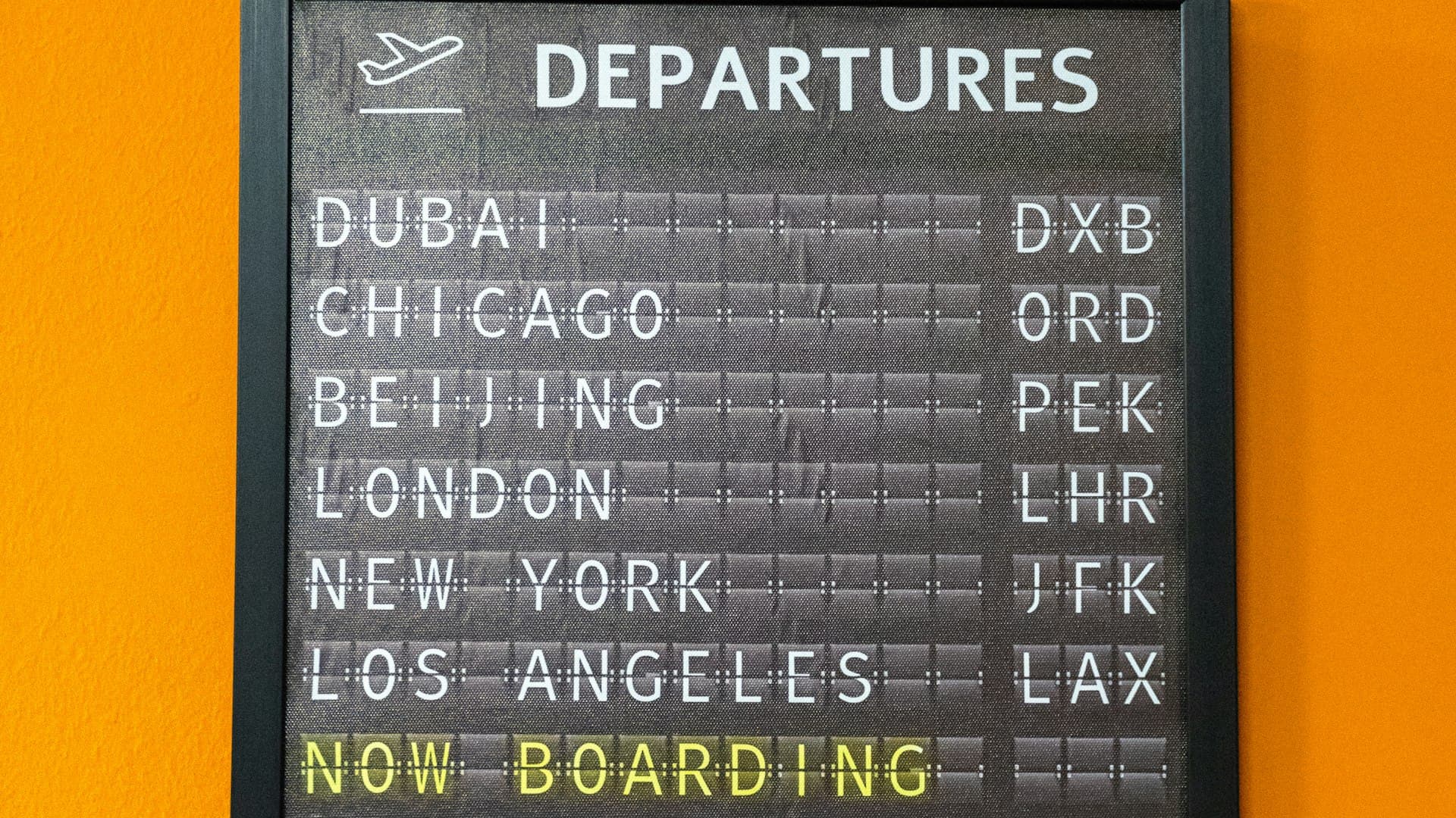An airport departure board listing multiple flights and destinations